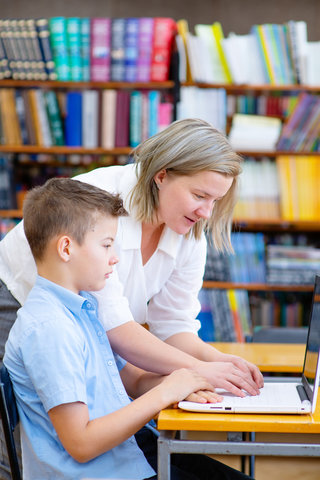 A tutor helping a pupil with schoolwork